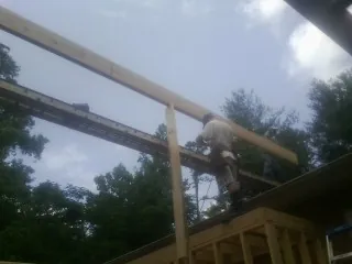 Carpenter setting a ridge beam over a new addition frame — Ice Dam Removal by Roofing Brothers in Danielsville